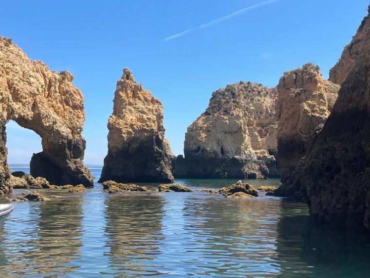 a large body of water with rock formations in the background